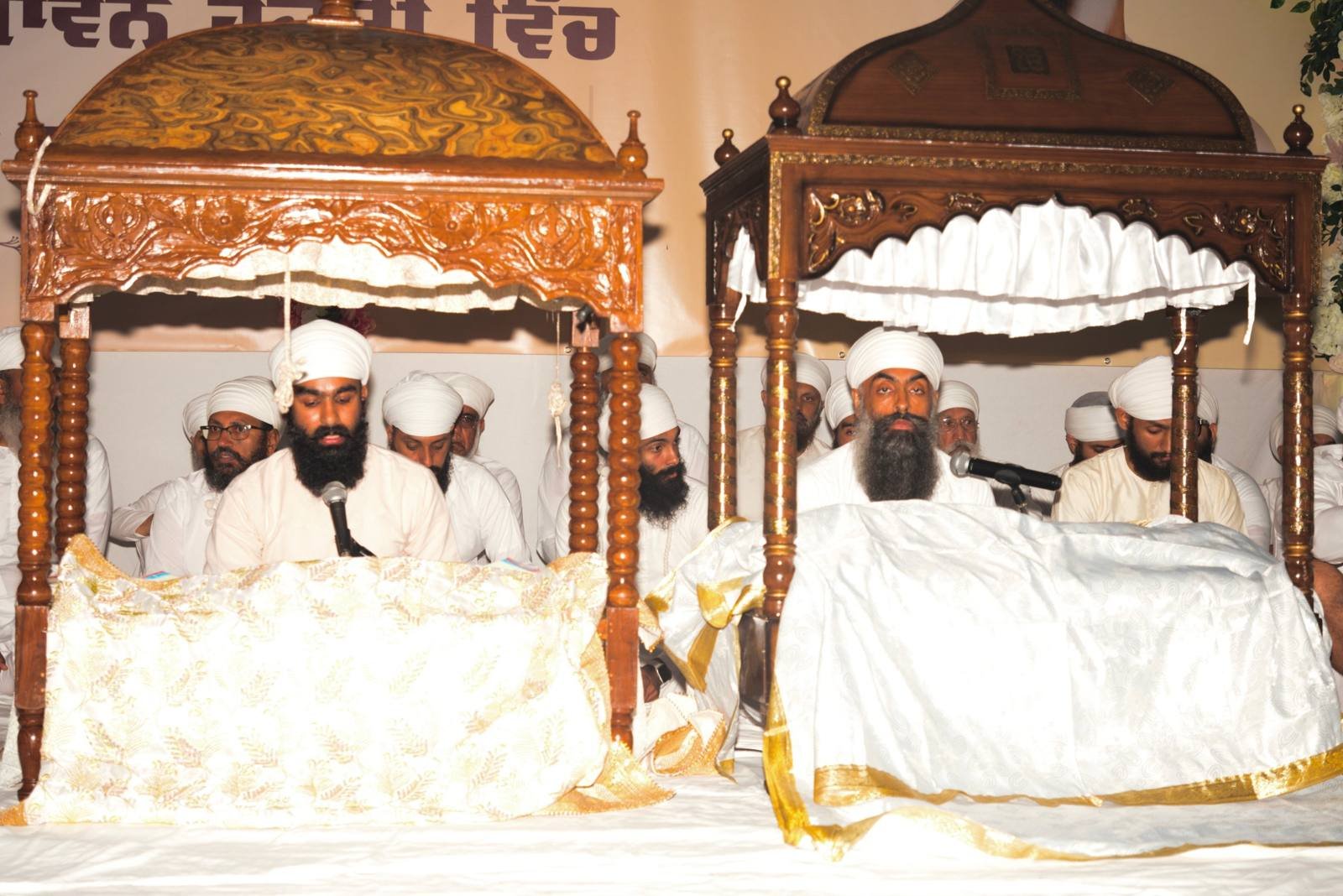 Granthi Singhs reading from Sri Guru Granth Sahib under carved wooden palkis